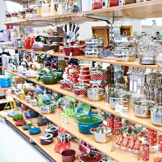 Regale mit Kochgeschirr, Wasserkochern und Küchenartikeln auf einem Haushaltswarenmarkt