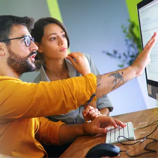 Two people examining information on a computer
