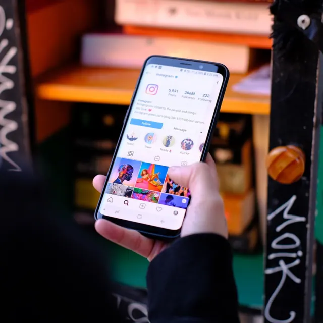 Hand hält ein Smartphone mit einem Instagram-Profil