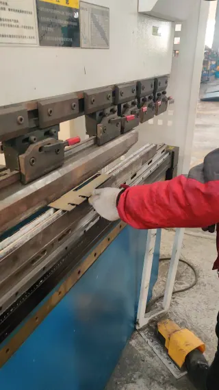 操作人员在车间使用折弯机折弯钣金零件。